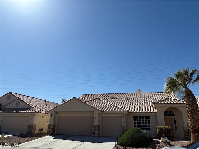 view of front facade featuring stucco siding, driveway, a tile roof, a garage, and a chimney