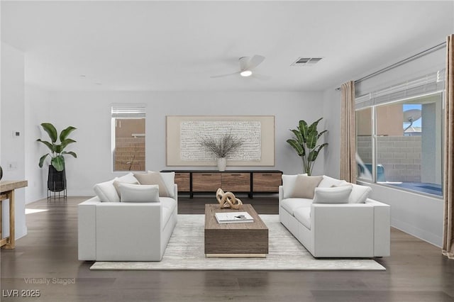 living room featuring a ceiling fan, visible vents, and wood finished floors