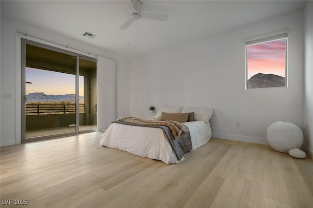 bedroom with access to outside, multiple windows, visible vents, and wood finished floors