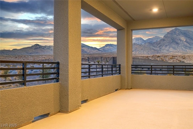 patio terrace at dusk with a mountain view and a balcony