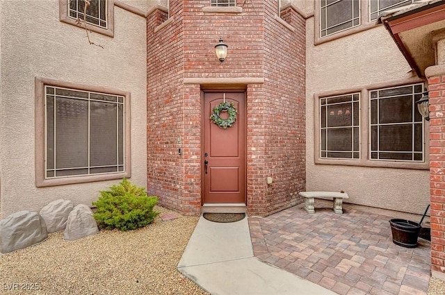 entrance to property with brick siding and stucco siding