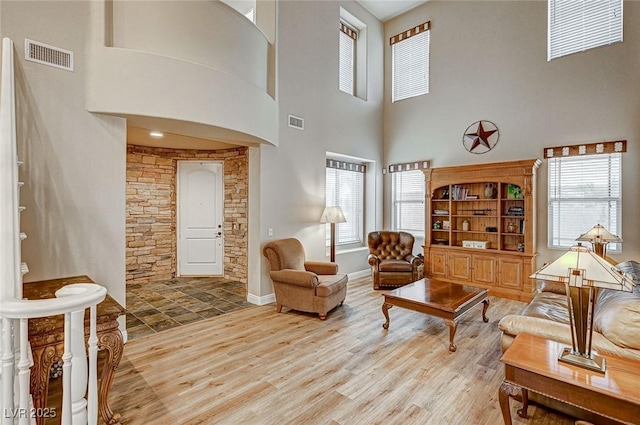 living area with a healthy amount of sunlight, visible vents, and wood finished floors