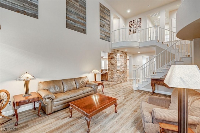 living area featuring stairs, wood finished floors, and baseboards