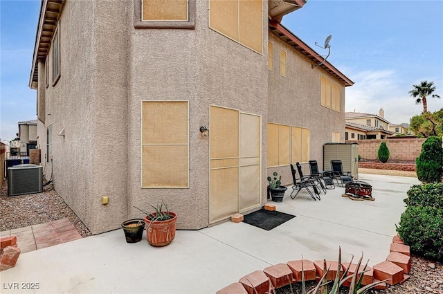 exterior space featuring central air condition unit, a patio, and stucco siding