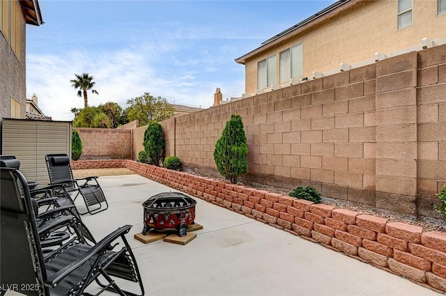 view of patio featuring an outdoor fire pit and a fenced backyard