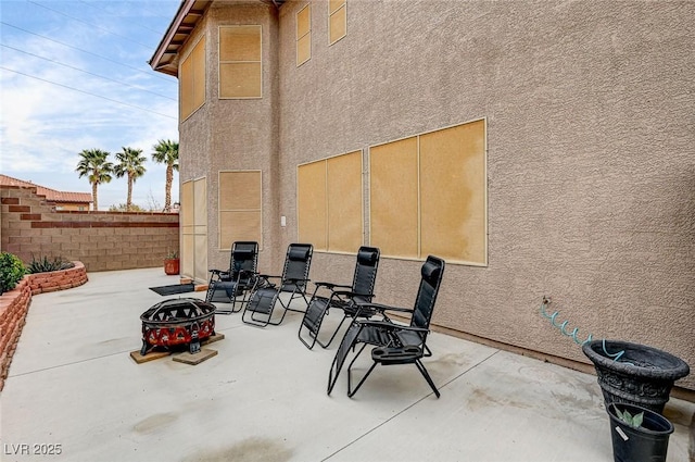 view of patio / terrace featuring an outdoor fire pit and fence