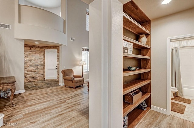 walk in closet featuring visible vents, a high ceiling, and wood finished floors