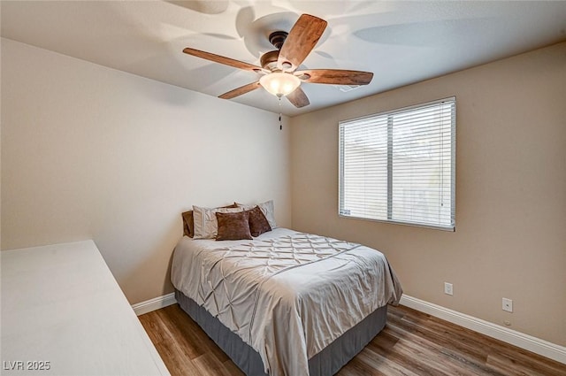 bedroom featuring ceiling fan, baseboards, and wood finished floors