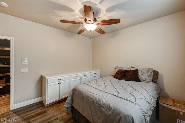 bedroom featuring dark wood-style floors, ceiling fan, and baseboards