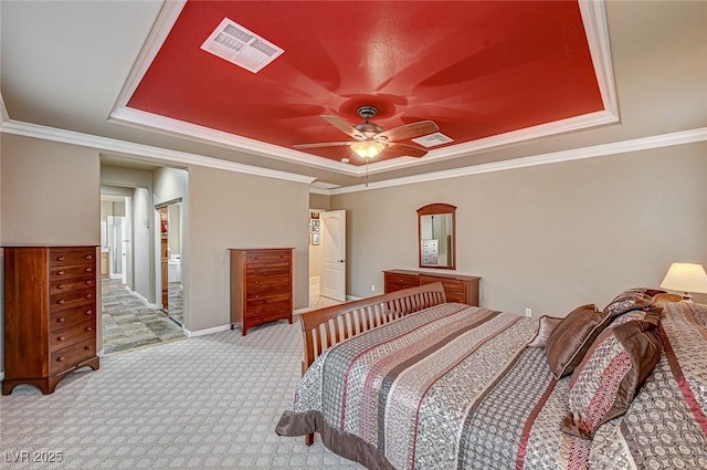 bedroom with ensuite bathroom, carpet flooring, a raised ceiling, and visible vents