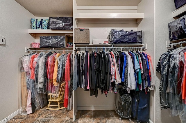 spacious closet with stone finish flooring