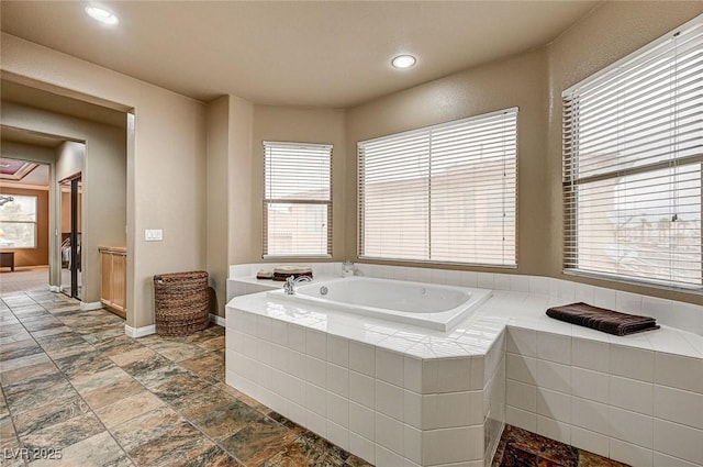 full bathroom with a healthy amount of sunlight, a garden tub, baseboards, and recessed lighting