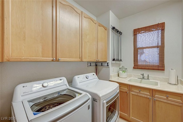 washroom with cabinet space, washing machine and dryer, and a sink