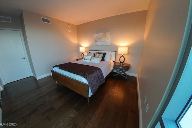 bedroom with visible vents, baseboards, and wood finished floors