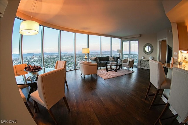 living area with expansive windows, dark wood-style flooring, and a view of city