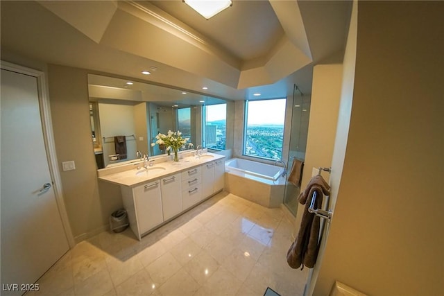 bathroom with double vanity, a garden tub, a walk in shower, and a sink