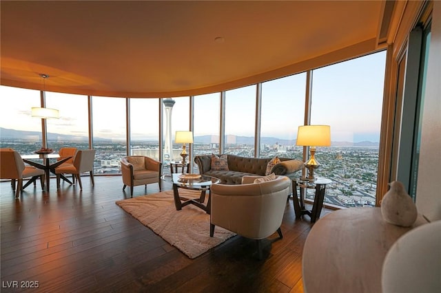 living room featuring a view of city, dark wood-style flooring, and floor to ceiling windows