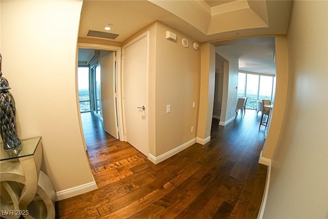 hall with attic access, dark wood finished floors, and baseboards