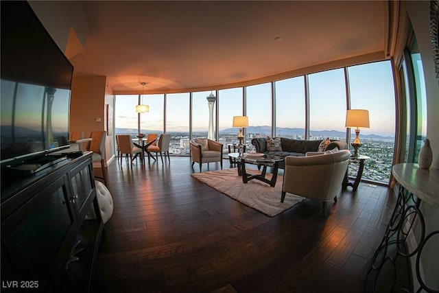 living room featuring a wall of windows and dark wood-style flooring