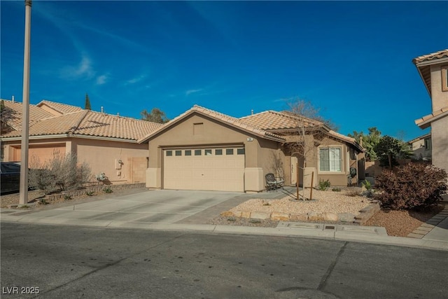 mediterranean / spanish-style house featuring a garage, concrete driveway, a tiled roof, and stucco siding