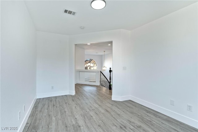 empty room with visible vents, baseboards, and wood finished floors