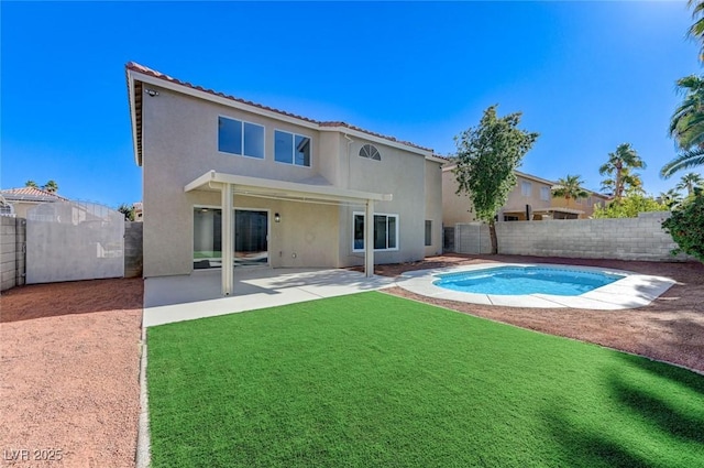 back of property with a patio, a yard, a fenced backyard, and stucco siding