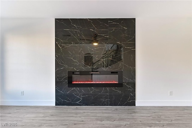 interior details with a fireplace, baseboards, and wood finished floors