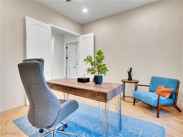 home office featuring light wood-type flooring and wallpapered walls