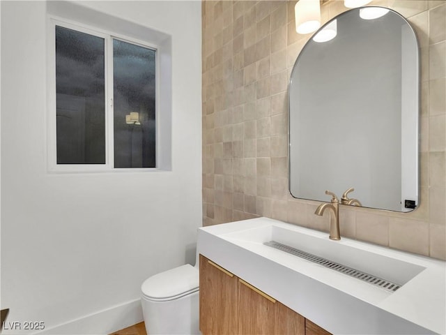 bathroom with toilet, decorative backsplash, tile walls, and vanity