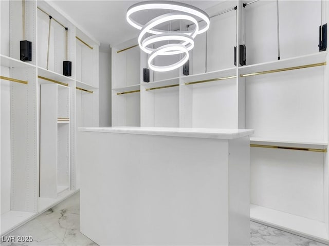 spacious closet featuring marble finish floor