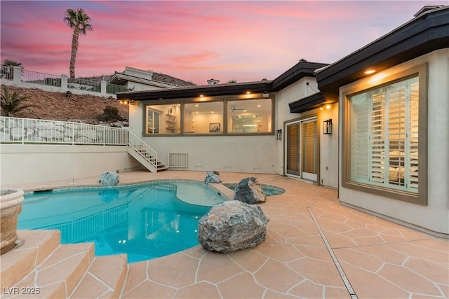 pool at dusk with a patio and a fenced in pool