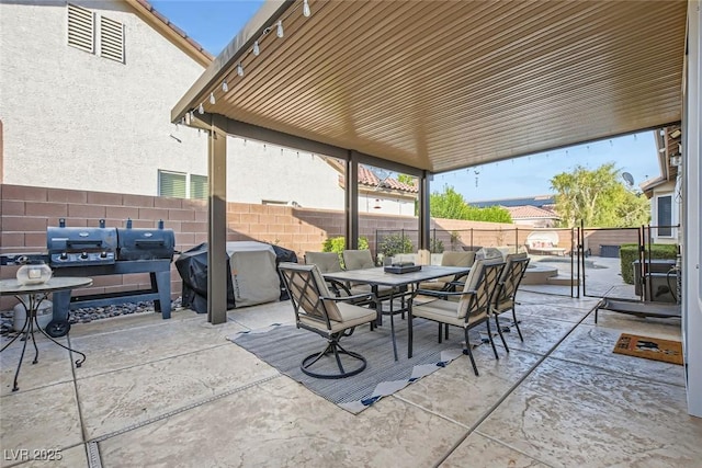 view of patio featuring outdoor dining area, a fenced backyard, and a grill