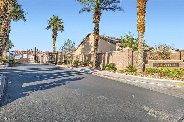 view of street featuring sidewalks, a gate, a gated entry, and curbs