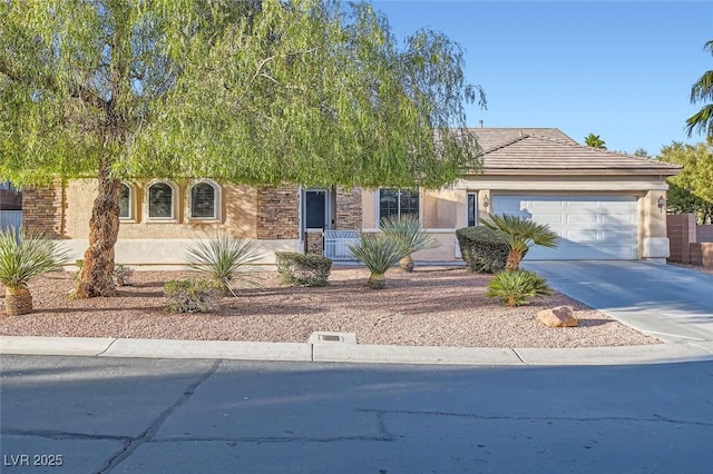 view of front of property featuring a tile roof, driveway, an attached garage, and stucco siding