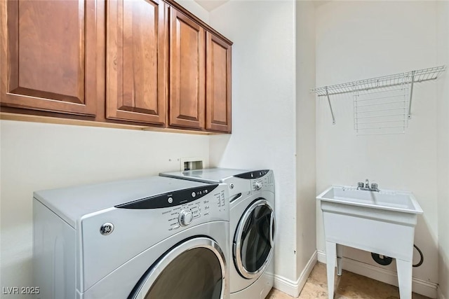 laundry area featuring washer and dryer, cabinet space, a sink, and baseboards