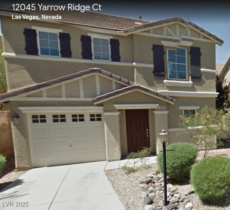 view of front of home featuring a garage, concrete driveway, a tile roof, and stucco siding