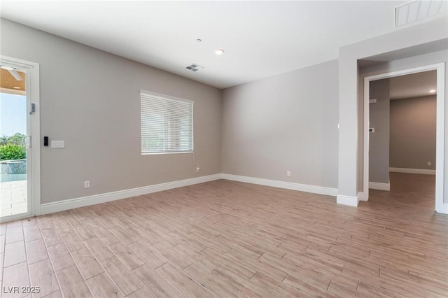 unfurnished room with light wood finished floors, baseboards, and visible vents