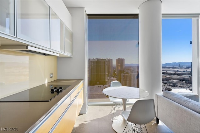 kitchen featuring white cabinets, a mountain view, black electric stovetop, and expansive windows