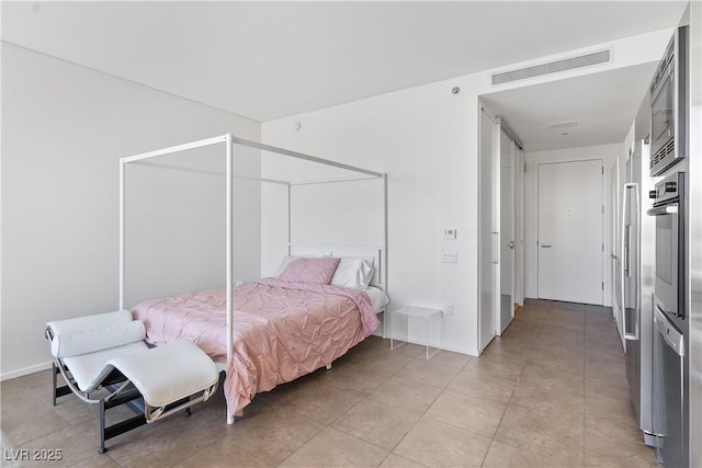 bedroom with light tile patterned flooring, visible vents, and baseboards