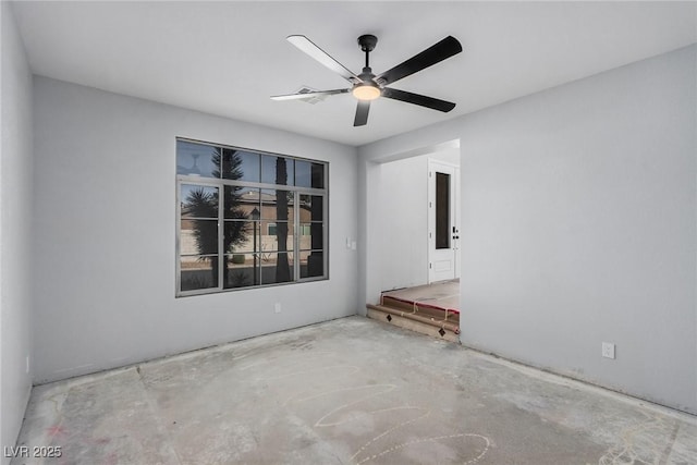 unfurnished room with a ceiling fan and unfinished concrete floors