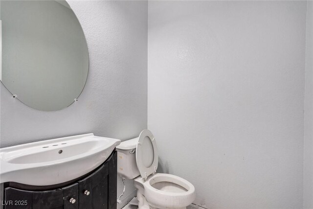 half bathroom with toilet and vanity