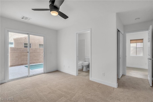 unfurnished bedroom featuring carpet floors, access to outside, visible vents, and ensuite bath