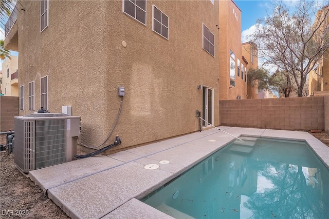 view of swimming pool featuring fence, a patio, and central air condition unit