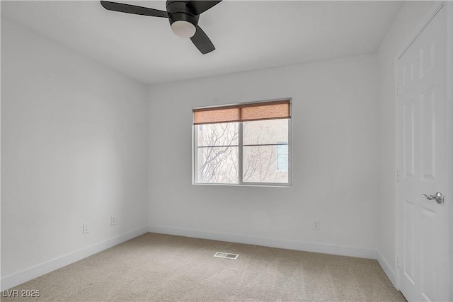 empty room featuring baseboards, visible vents, a ceiling fan, and light colored carpet