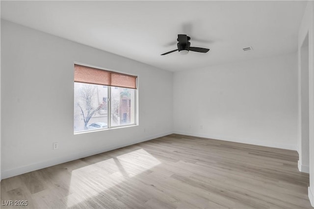 unfurnished room with light wood-type flooring, ceiling fan, and baseboards