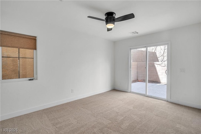 carpeted empty room with a ceiling fan, visible vents, and baseboards