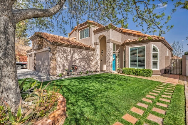 mediterranean / spanish house featuring a tile roof, stucco siding, an attached garage, a front yard, and a gate