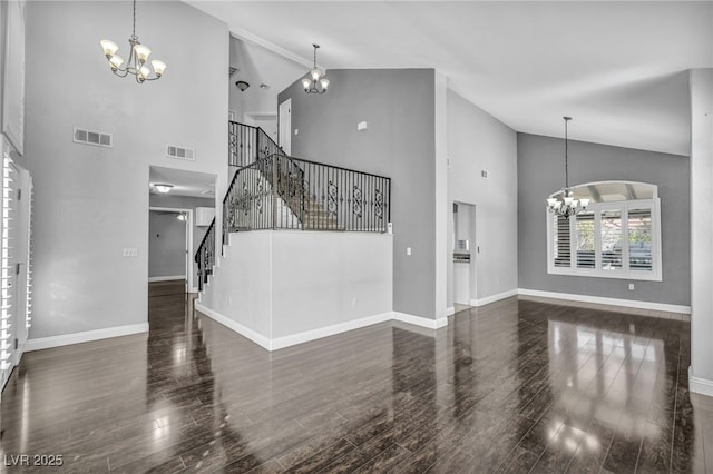 unfurnished living room with stairway, visible vents, and a chandelier