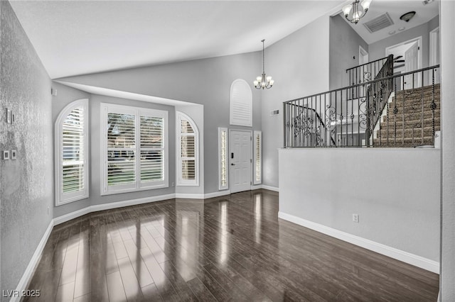 foyer featuring a notable chandelier, stairway, baseboards, and wood finished floors