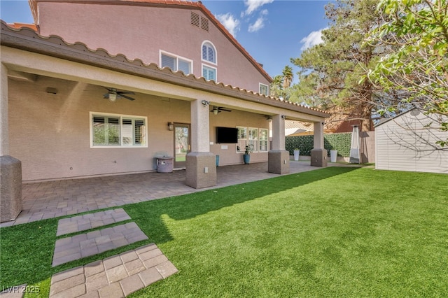 back of property featuring stucco siding, a yard, a patio, and fence